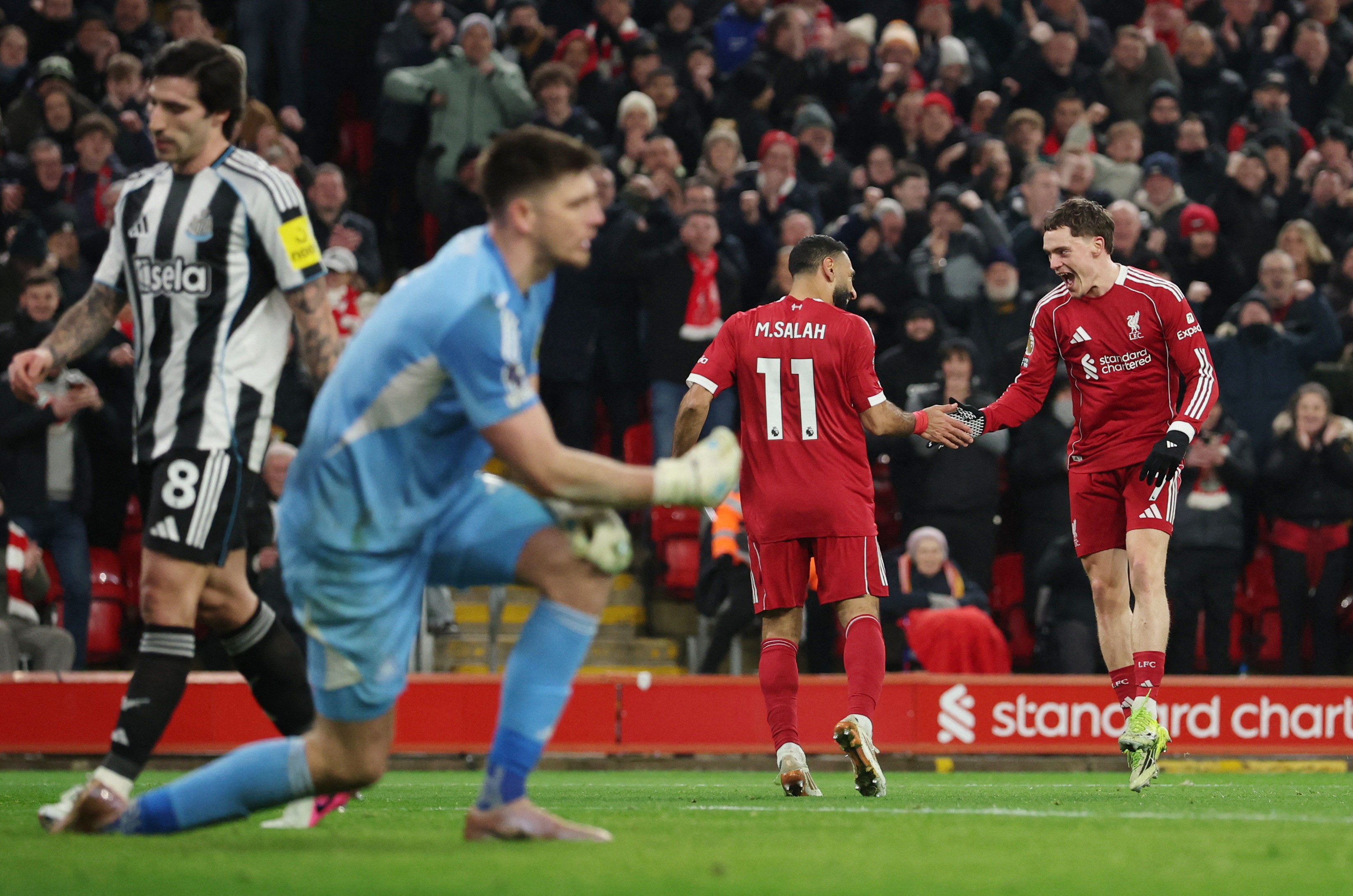 Florian Wirtz celebrates scoring their third goal with Liverpool's Mohamed Salah