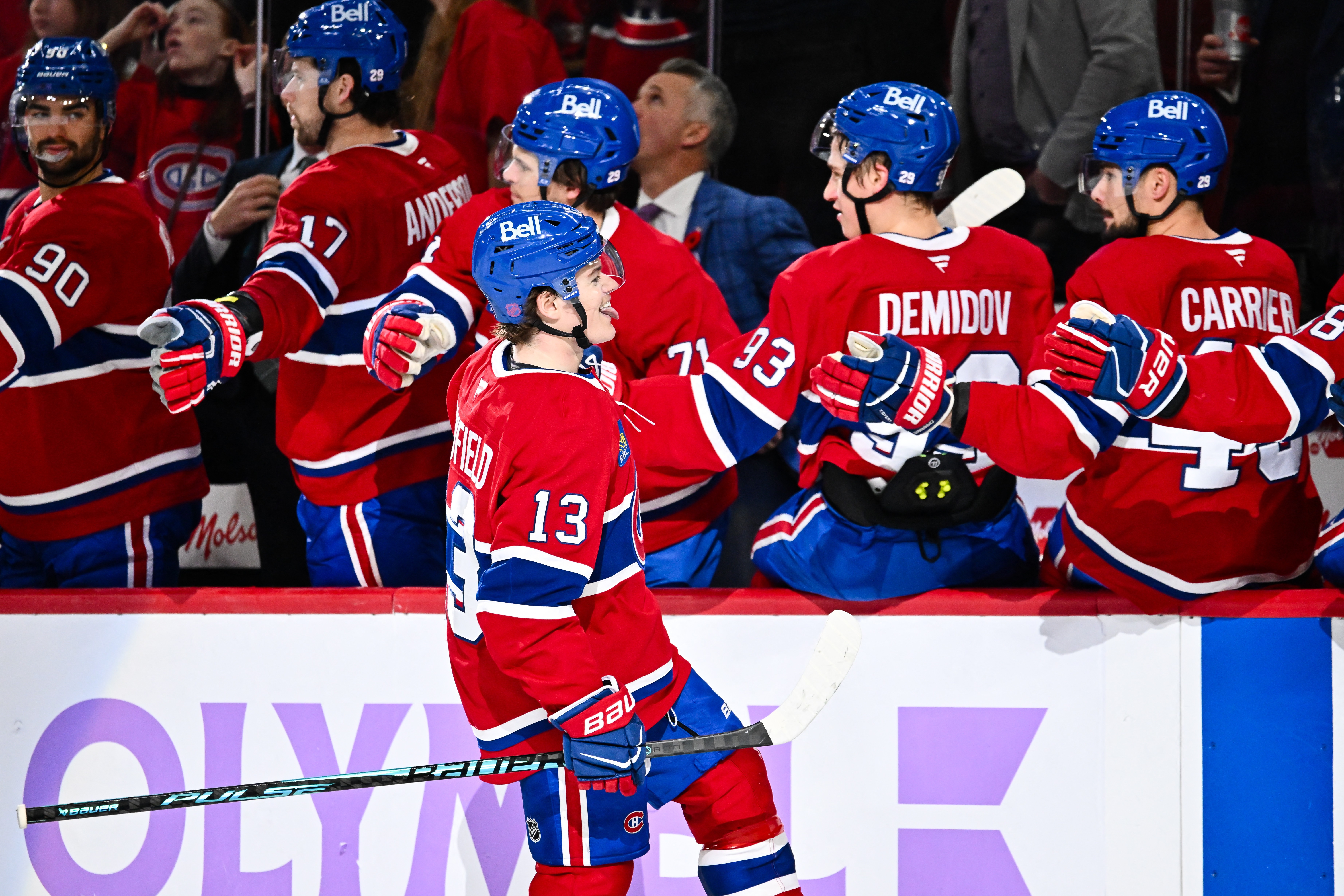 Cole Caufield celebrates a goal with teammates
