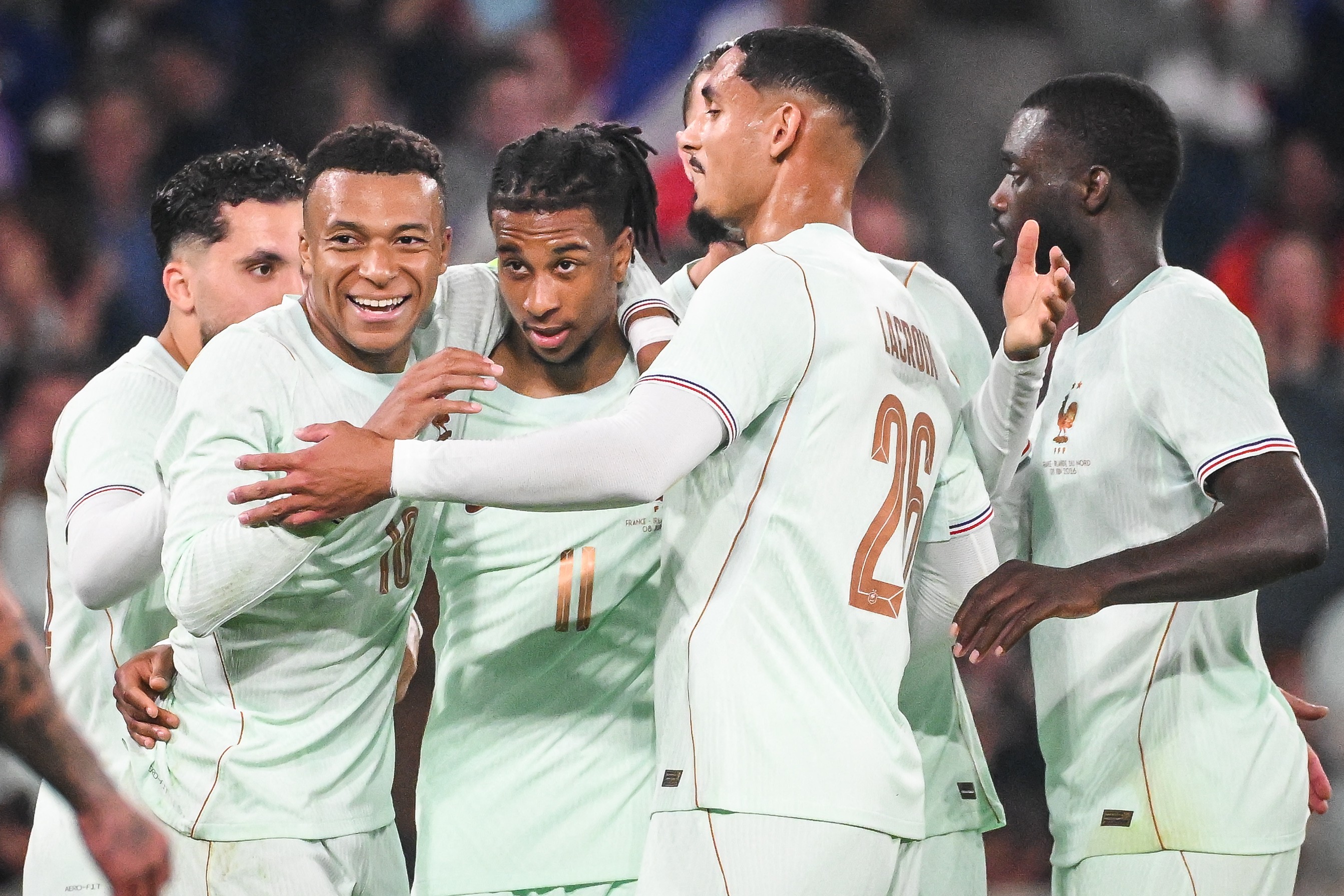Michael Olise is swarmed by teammates after scoring