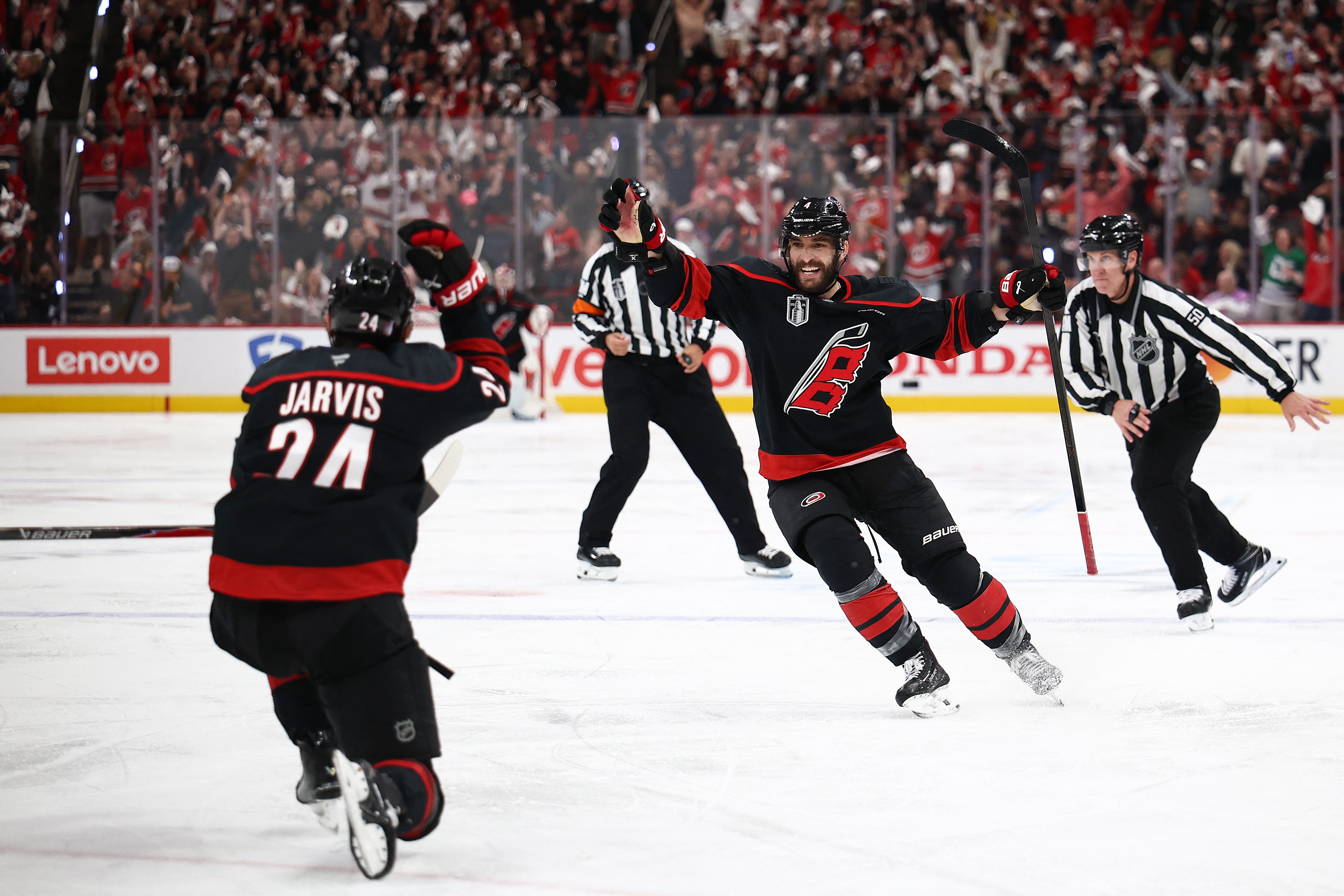 Hurricanes' Seth Jarvis and Shayne Gostisbehere (right) celebrate Game 2 overtime goal against Golden Knights