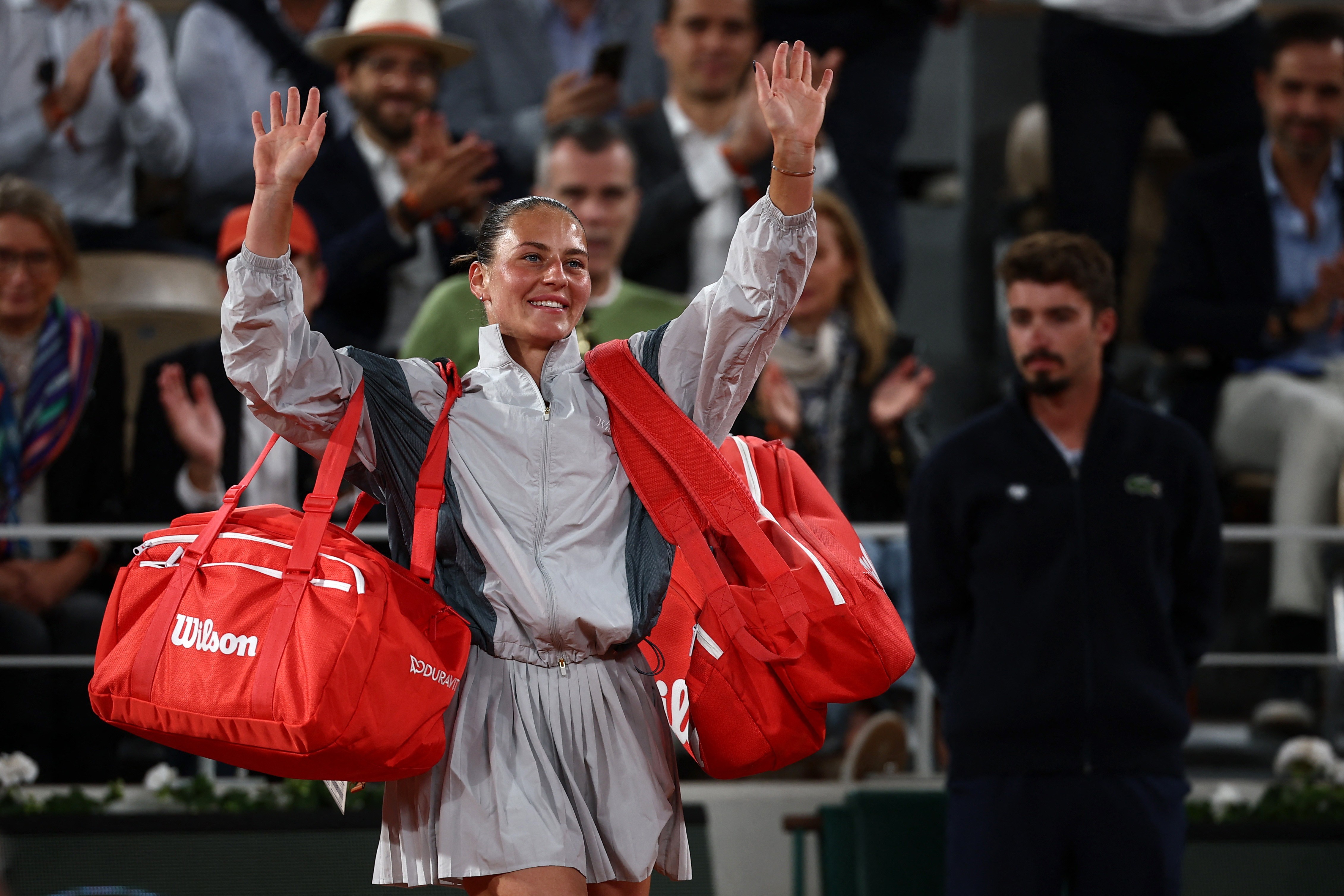 Marta Kostyuk waves to the crowd after her defeat