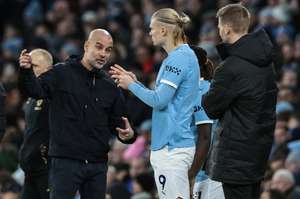 Guardiola (left) addresses Haaland