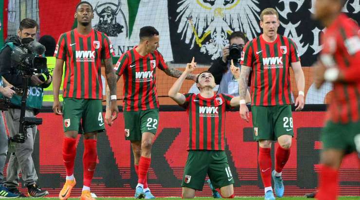 VÀO - 2:1! Quả phạt góc đến và Andre Hahn chạm nhẹ bằng đầu tới chỗ Ruben Vargas (Augsburg), người không mắc một sai lầm nào để sút bóng vào lưới.