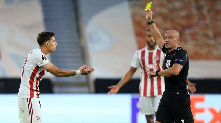 Konstantinos Tsimikas (Olympiakos Piraeus) nhận một chiếc thẻ vàng từ Szymon Marciniak sau khi anh ấy khiến một cầu thủ đối phương nằm sân.