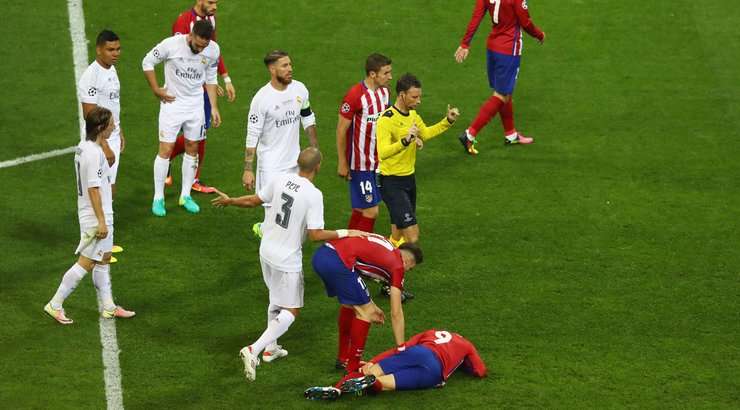 Mark Clattenburg thổi còi. Pepe (Real Madrid) đã phạm lỗi khi anh ấy đá vào chân đối phương thay vì đá bóng. Quả phạt đền cho Atl. Madrid. Các cầu thủ đối phương đang cố gắng tranh cãi một cách giận dữ với trọng tài, nhưng quả penalty này là quá rõ ràng.