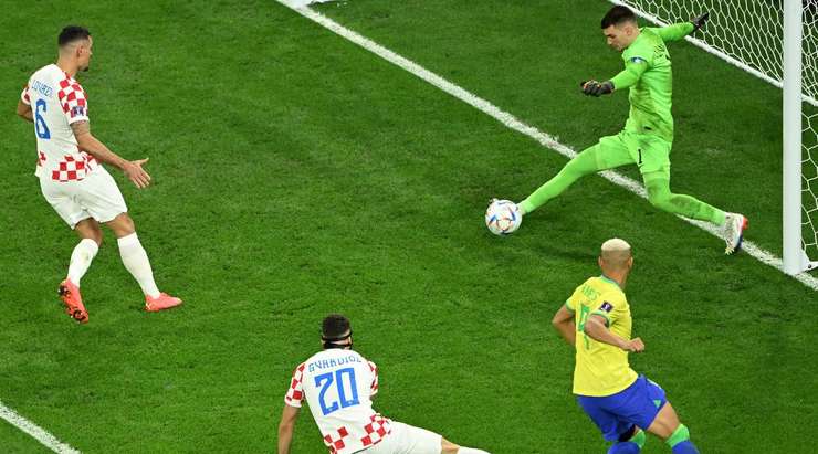 Một cơ hội không được tận dụng! Eder Militao (Brazil) chuyền bóng vào vòng cấm, nhưng thủ môn Dominik Livakovic đã phản ứng rất tốt hóa giải pha tấn công.