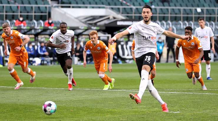 Vào! Ramy Bensebaini (B. Monchengladbach) giành chiến thắng trên chấm phạt đền bằng một cú sút không thể cản phá, vượt qua tầm với của thủ môn Stefan Ortega vào góc thấp bên phải.