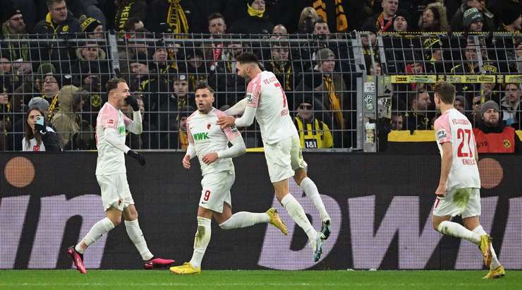 Một bàn thắng đẹp mắt! Ermedin Demirovic (Augsburg) nhận bóng tại rìa vòng 16m50 và nhận thấy thủ môn đối phương đang dâng lên cao. Anh có một cú lốp bóng hoàn hảo qua đầu Gregor Kobel và đi thẳng vào lưới. Arne Engels là người kiến tạo. 2:2.