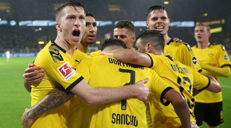 Vào! Trong một tình huống hỗn loạn ở bên trong vòng cấm, Marco Reus vẫn kịp chích mũi giày chuyền bóng cho Jadon Sancho (Dortmund), và cầu thủ này không đợi phải mời lần thứ hai để sút tung nóc lưới bên phải khung thành. Tỉ số là 3:2.
