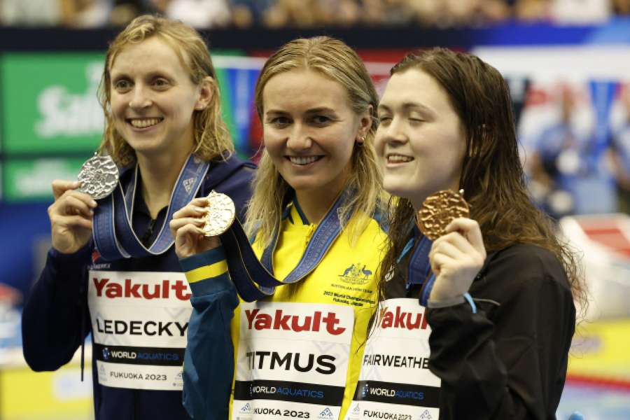 Ariarne Titmus celebrates after winning the women's 400m freestyle final alongside Katie Ledecky and Erika Fairweather