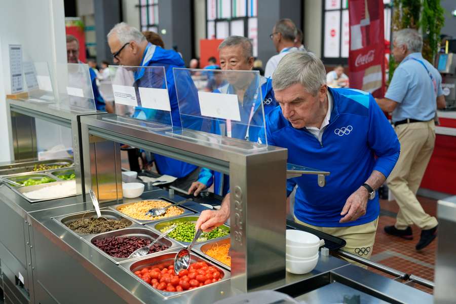 Thomas Bach, presidente del COI, se sirve la comida.