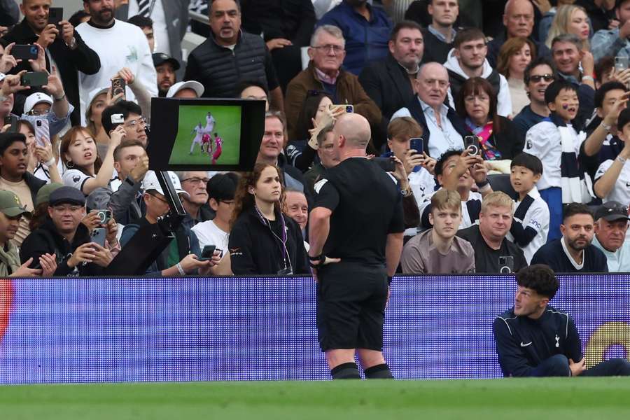 Simon Hooper raadpleegt de VAR voor een rode kaart voor Curtis Jones tijdens Tottenham-Liverpool