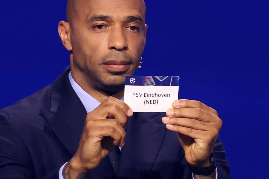 Thierry Henry holds PSV's ticket during the Champions League draw Thierry Henry holds PSV's ticket during the Champions League draw