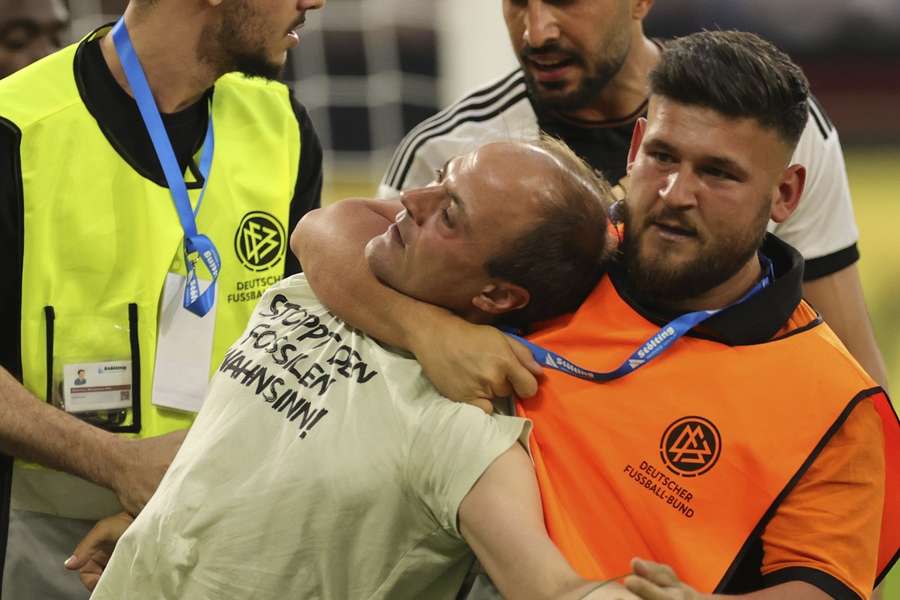 Toeschouwers lopen veld op bij oefenwedstrijd Duits elftal tegen Colombia bij een 0-0 stand