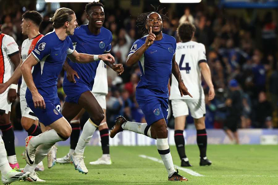 Chelsea midfielder Raheem Sterling (R) celebrates with teammates after scoring the opening goal