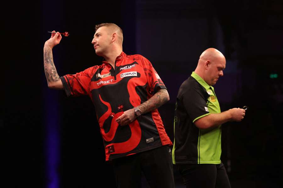 Nathan Aspinall throws against Michael van Gerwen during their quarter-final showdown on Thursday
