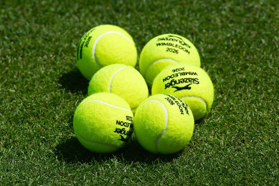 Slazenger-branded 2026 tennis balls lie on the green grass tennis courts of the All England Lawn Tennis and Croquet Club