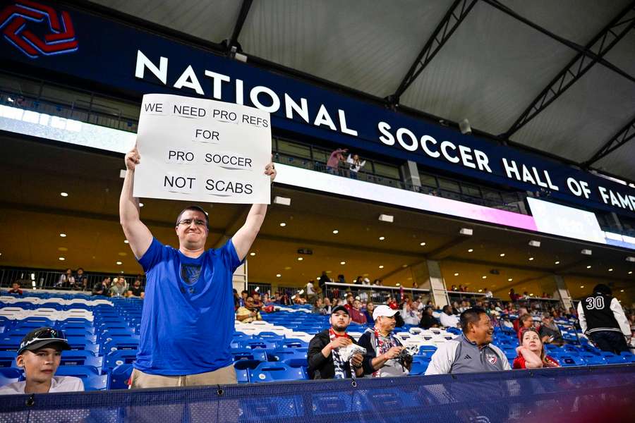An MLS fan holds up a sign in protest of stand-in referees