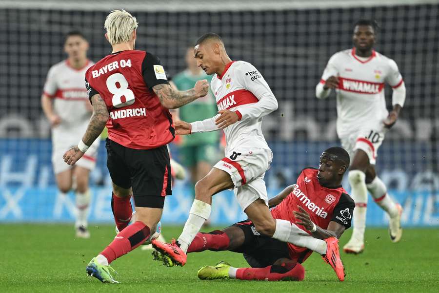 Bayer Leverkusen's Robert Andrich, Stuttgart's Enzo Millot and Bayer Leverkusen's Nordi Mukiele vie for the ball 