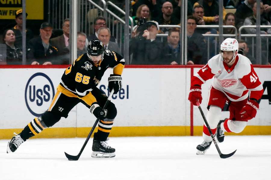Pittsburgh Penguins defenseman Erik Karlsson moves the puck against Detroit Red Wings defenceman Shayne Gostisbehere in overtime