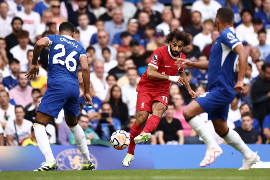 Liverpool's Egyptian striker #11 Mohamed Salah (C) crosses the ball to set up the opening goal