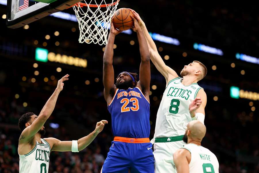 Kristaps Porzingis (8) foi o poste titular de Boston, e aqui tenta desarmar o lançamento de Mitchell Robinson.