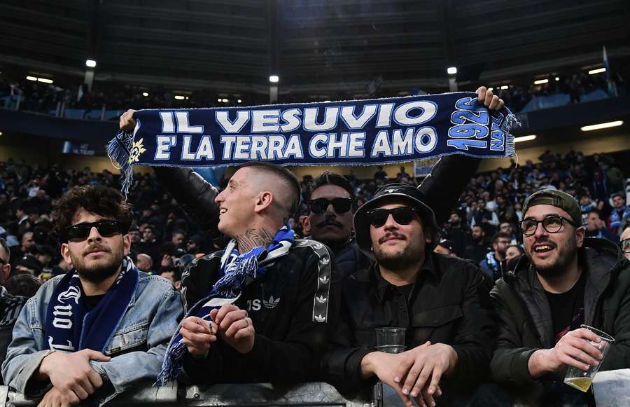 A Napoli's supporter hold a scarf reading 
