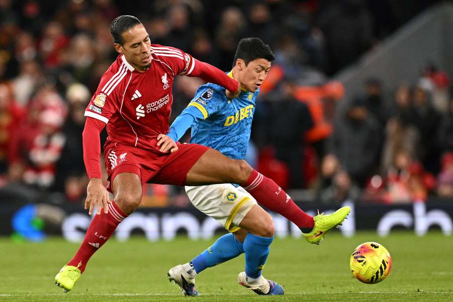 Liverpool's Dutch defender #04 Virgil van Dijk (L) vies with Wolverhampton Wanderers' South Korean striker #11 Hwang Hee-chan