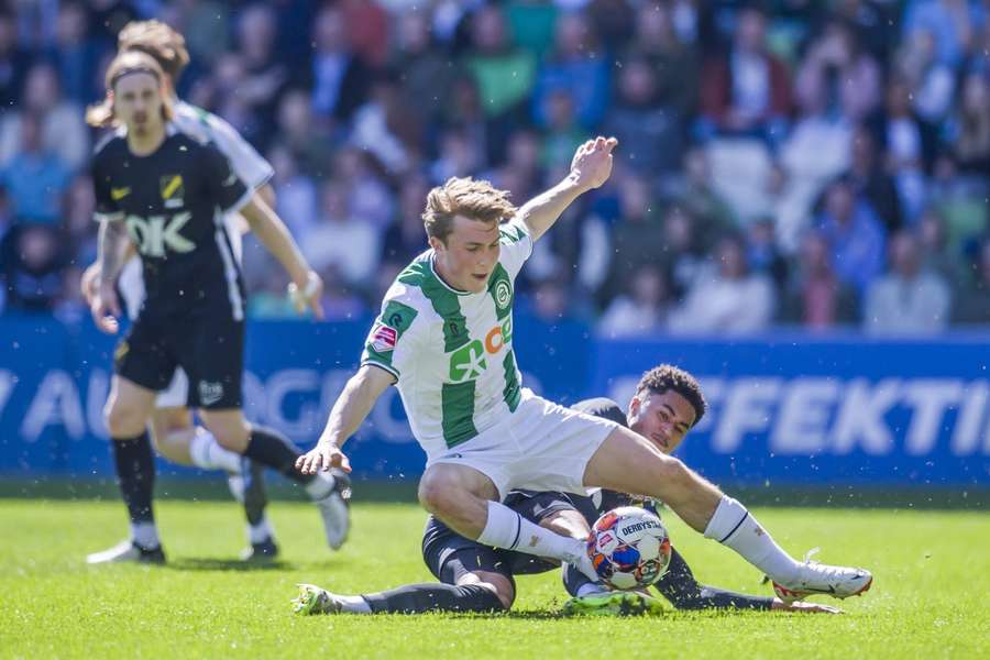 NAC's Aime Omgba met een tackle op Groningens Jorg Schreuders