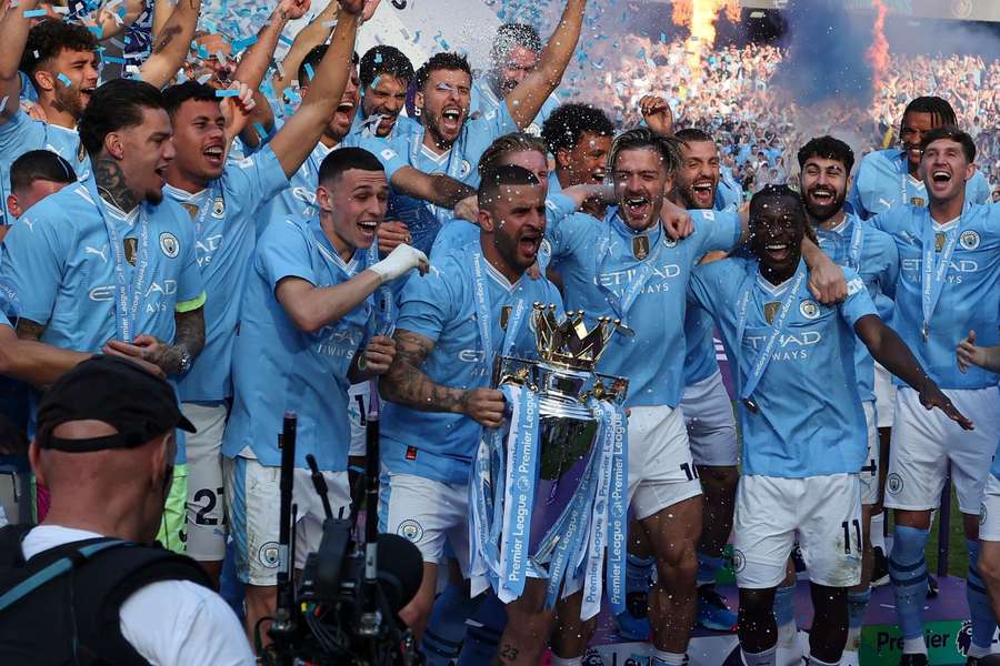 Manchester City players lift the Premier League trophy