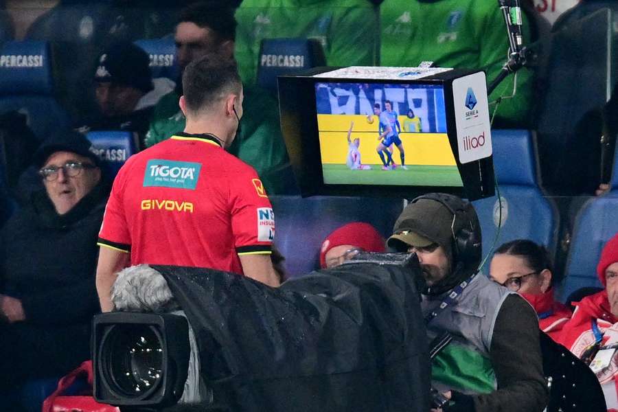 Arbitrul Ermano Feliciani se uită la un ecran VAR în timpul revizuirii unui penalty