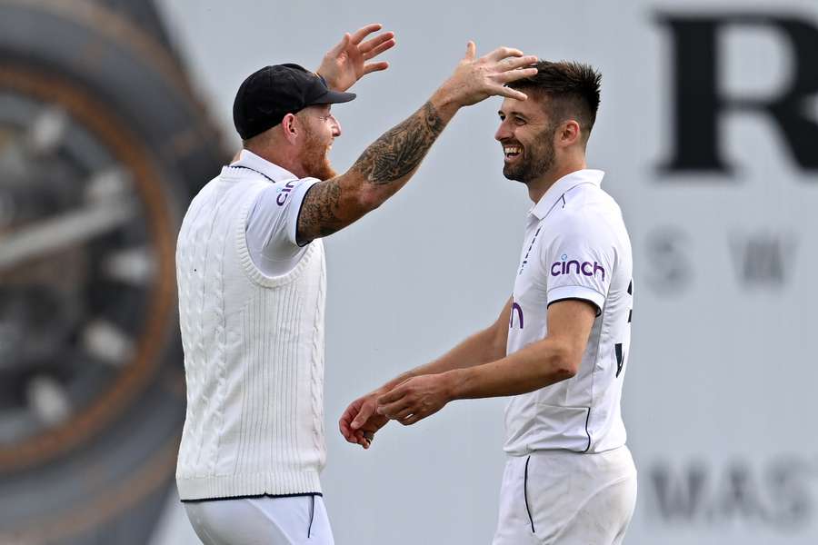 England's Mark Wood (R) is congratulated by England's captain Ben Stokes (L) after bowling Australia's Todd Murphy