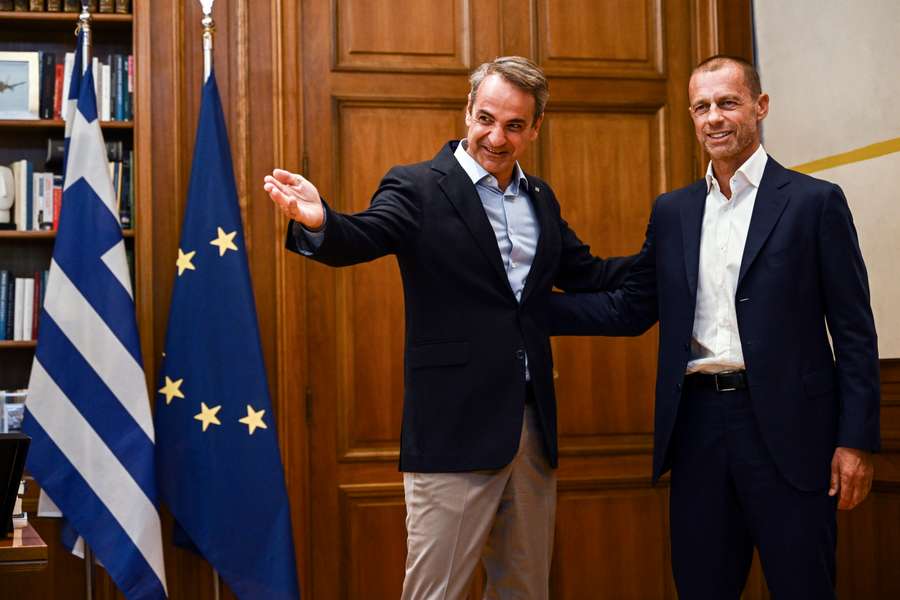 Greek Prime Minister Kyriakos Mitsotakis (L) welcomes UEFA President Aleksander Ceferin in his office