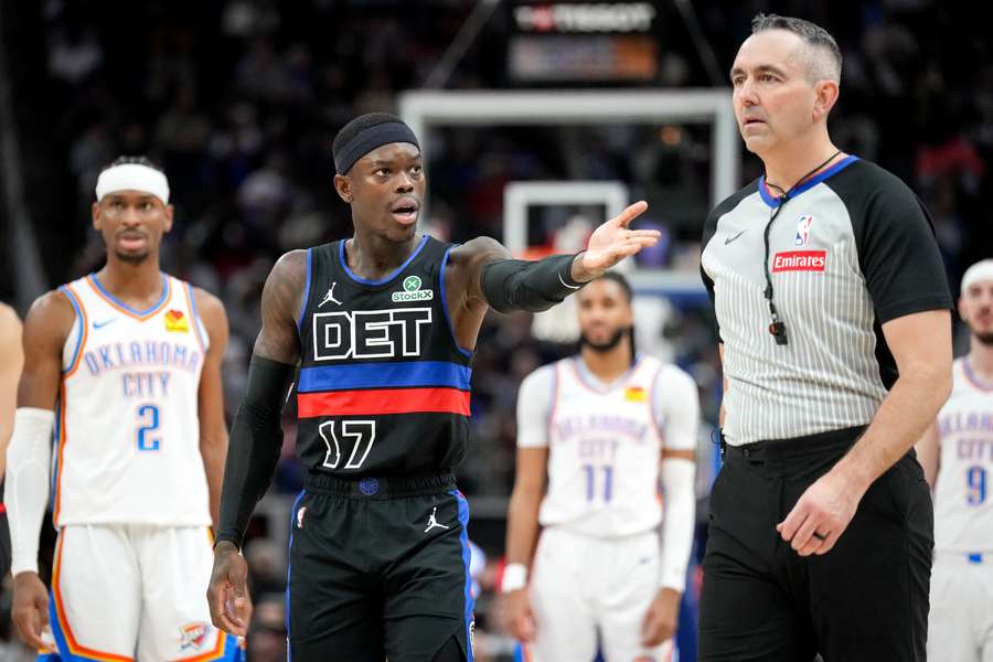 Dennis Schröder (M.) diskutiert mit Referee Brett Nansel (r.)
