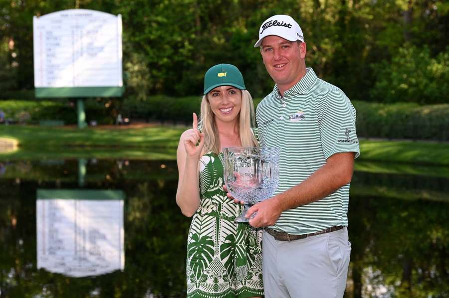 Tom Hoge and his wife, Kelly, pose with the Par 3 Contest trophy ahead of the Masters tournament