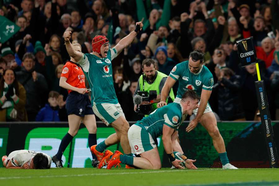 Ireland's Dan Sheehan celebrates with Josh van der Flier and James Lowe after scoring their fourth try against England