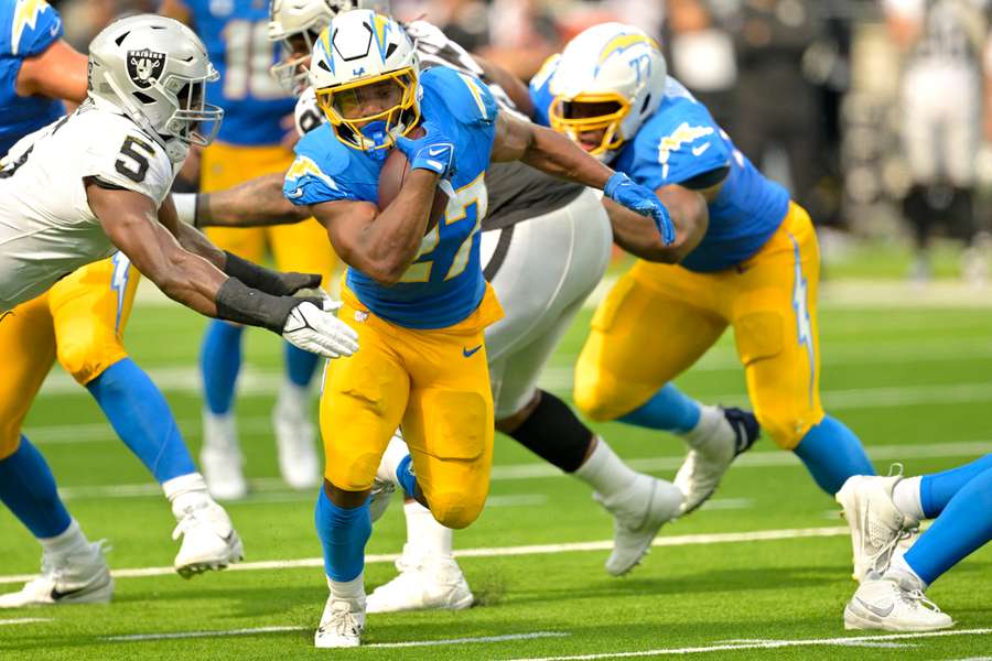 L'arrière des Chargers de Los Angeles, J.K. Dobbins, se détache du linebacker des Raiders de Las Vegas, Divine Deablo, et court pour marquer un touchdown en deuxième mi-temps.