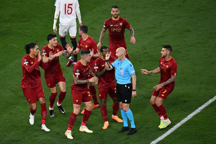 Roma players argue with referee Anthony Taylor