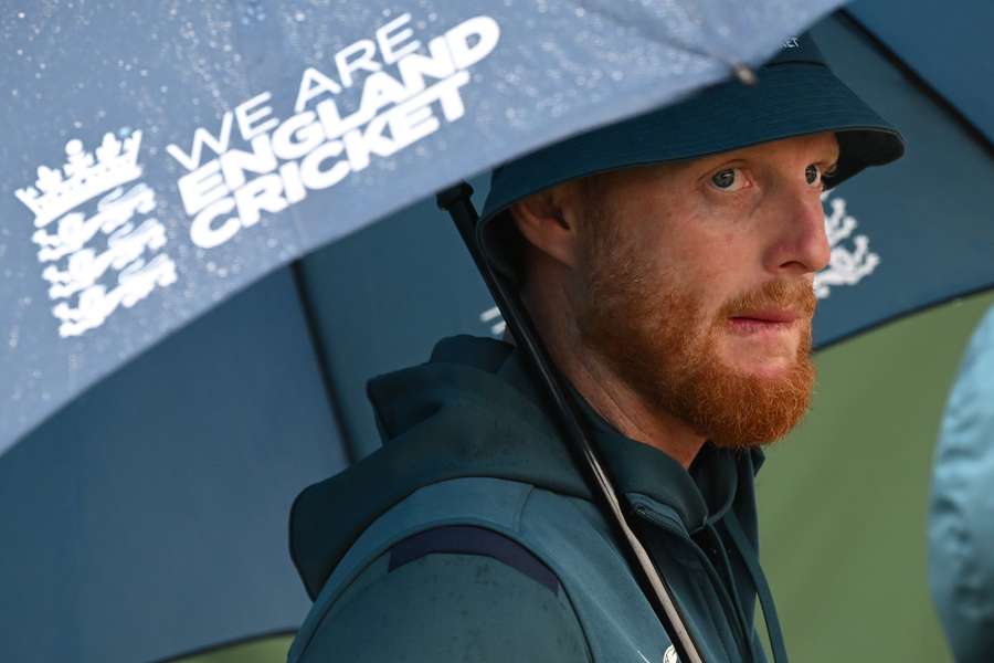 England's captain Ben Stokes shelters under an umbrella after the game is abandoned without any play on day five of the fourth Ashes cricket Test