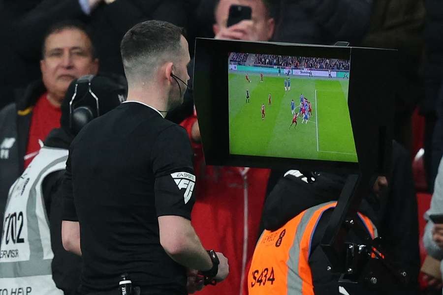 English referee Chris Kavanagh checks the pitch-side monitor before overturning a 'goal' by Liverpool's Dutch defender #04 Virgil van Dijk