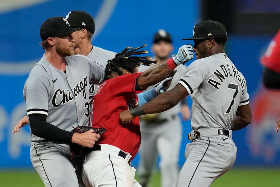 Cleveland Guardians' Jose Ramirez (C) and Chicago White Sox's Tim Anderson (R) exchange punches