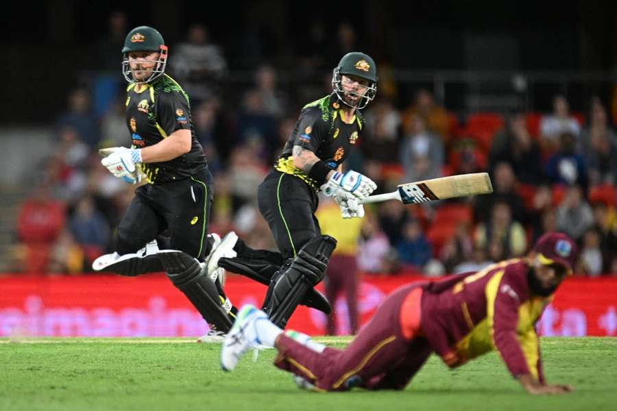 Aaron Finch (left) and Matthew Wade of Australia run between wickets during the first T20 match between Australia and the West Indies.