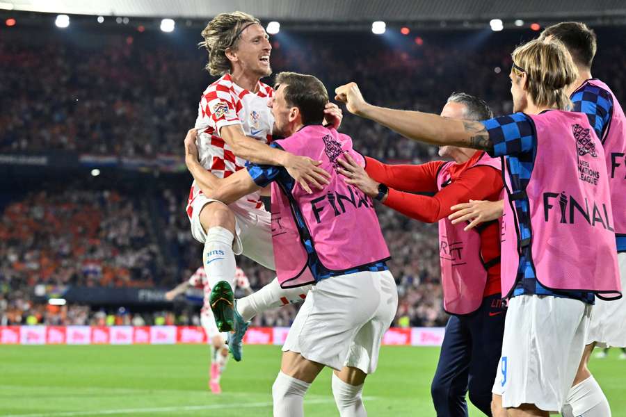 Chorwacki pomocnik Luka Modric (L) świętuje z kolegami z drużyny po zdobyciu czwartej bramki podczas półfinałowego meczu Ligi Narodów UEFA pomiędzy Holandią a Chorwacją.