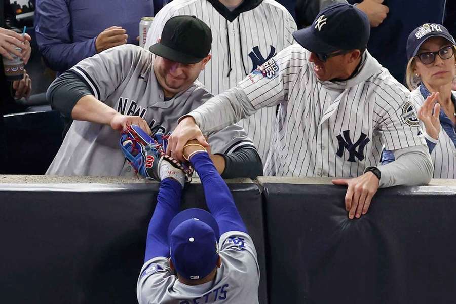 Austin Copabianco (linksboven) en zijn broer Darren proberen de bal uit Mookie Betts' handschoen te rukken