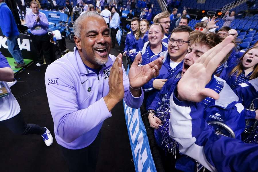 Coach Jerome Tang van Kansas State viert de overwinning met de pepband