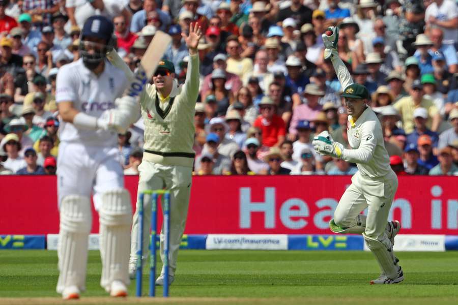 Australia's wicket keeper Alex Carey (R) reacts after taking the catch to dismiss England's Moeen Ali