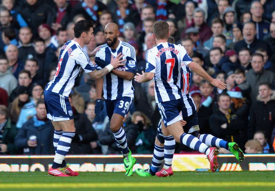 Nicolas Anelka of West Brom touches his sleeve as he celebrates scoring their first goal during the Barclays Premier League match against West Ham