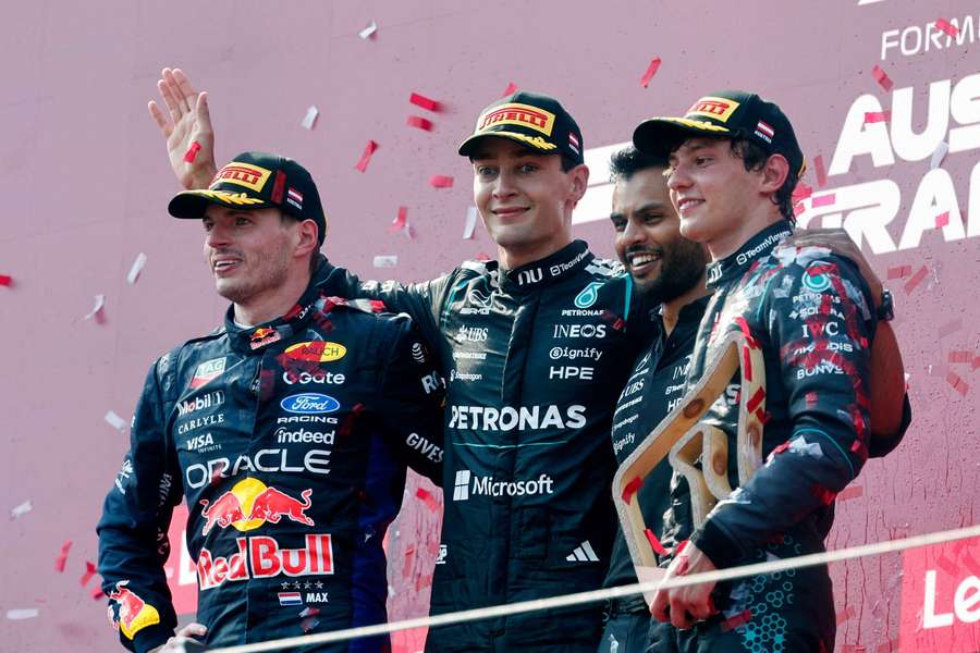 George Russell celebrates on the podium after winning the Austrian Grand Prix alongside Max Verstappen and Andrea Kimi Antonelli