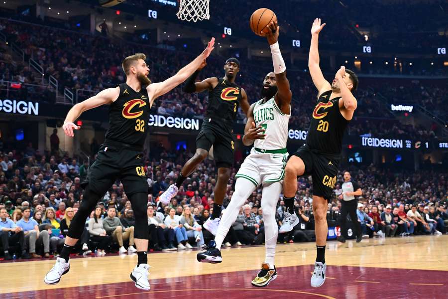 Dean Wade, Caris LeVert and Georges Niang of the Cleveland Cavaliers guard Jaylen Brown of the Boston Celtics