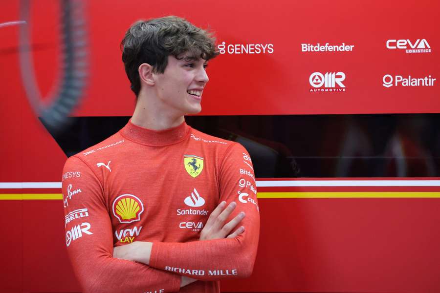 Ferrari reserve driver Oliver Bearman talks to a team member in the garage